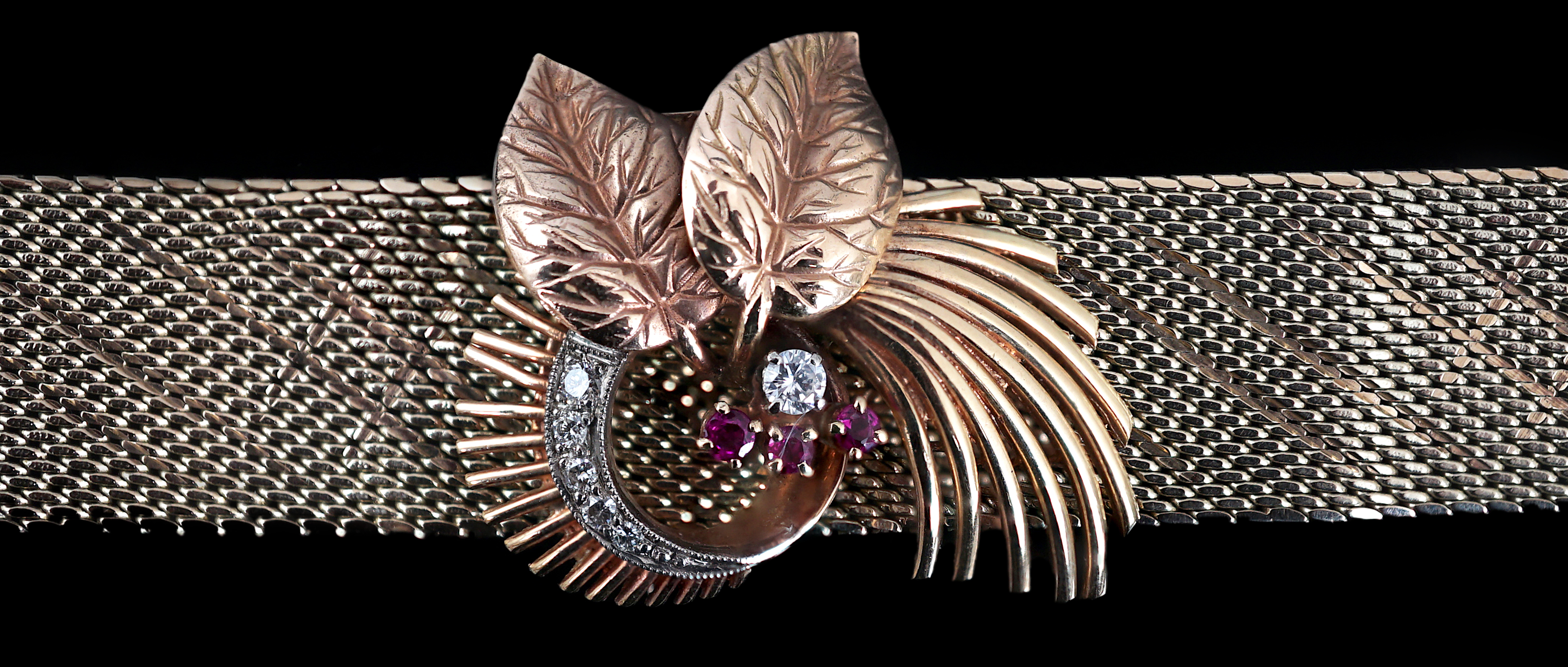 A 1960's 9ct gold ruby and diamond cluster set bracelet, with detachable central foliate scroll clip brooch